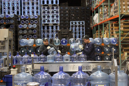 DrinkMore Water employees preparing large multi-gallon bottles